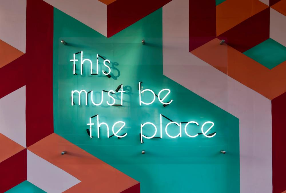 Neonschrift auf grüner Wand "This must be the place"